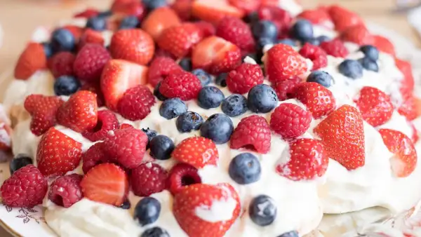 En härlig pavlova med vispgrädde och massor av färska bär. Ett perfekt pavlova recept för sommaren!